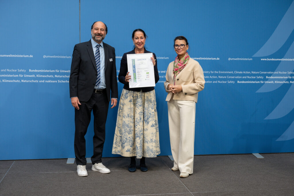 Ehrung der Stadt Herdecke auf dem gemeinsamen 2. Platz der "Recyclingpapierfreundlichsten Mittelstädte" 2026 mit der Stadt Hameln, v.l.n.r.: Marc Gebauer (Sprecher der Initiative Pro Recyclingpapier), Iris Stalzer (Bürgermeisterin der Stadt Herdecke), Parlamentarische Staatssekretärin Rita Schwarzelühr-Sutter ©IPR/Mark Bollhorst