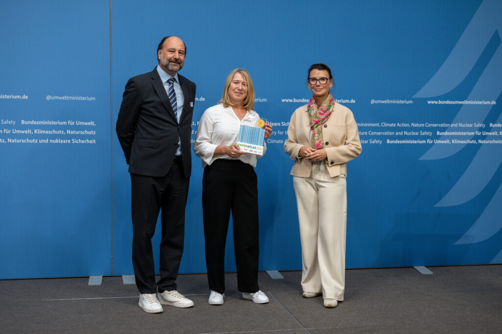Auszeichnung der Stadt Solingen als „Mehrfachsieger“ 2026, v.l.n.r.: Marc Gebauer (Sprecher der Initiative Pro Recyclingpapier), Ulrike Ermertz (Einkauf, Stadt Solingen), Parlamentarische Staatssekretärin Rita Schwarzelühr-Sutter ©IPR/Mark Bollhorst