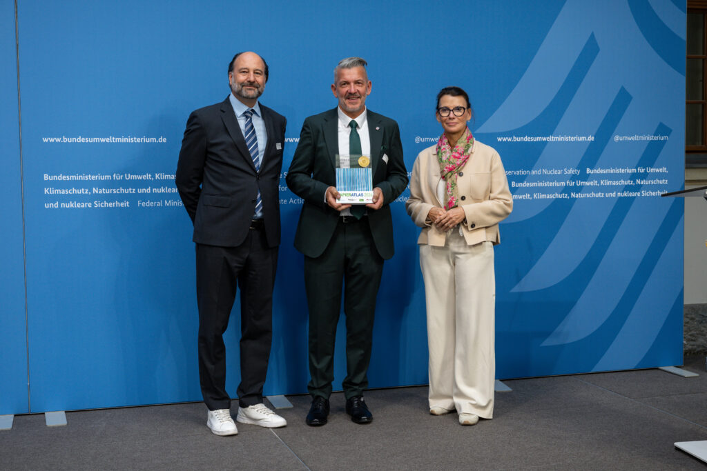 Auszeichnung des Unstrut-Hainich-Kreis als „Mehrfachsieger“ 2026, v.l.n.r.: Marc Gebauer (Sprecher der Initiative Pro Recyclingpapier), Thomas Ahke (Landrat des Unstrut-Hainich-Kreis), Parlamentarische Staatssekretärin Rita Schwarzelühr-Sutter ©IPR/Mark Bollhorst