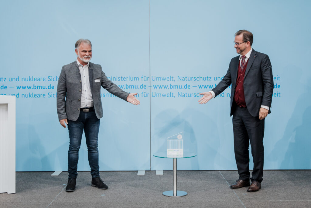 Harald Zanker, Landrat des Unstrut-Hainich-Kreis, nimmt den Award für die Auszeichnung als "Aufsteiger des Jahres" von Parlamentarischer Staatssekretär Florian Pronold entgegen. © BMU/Sascha Hilgers
