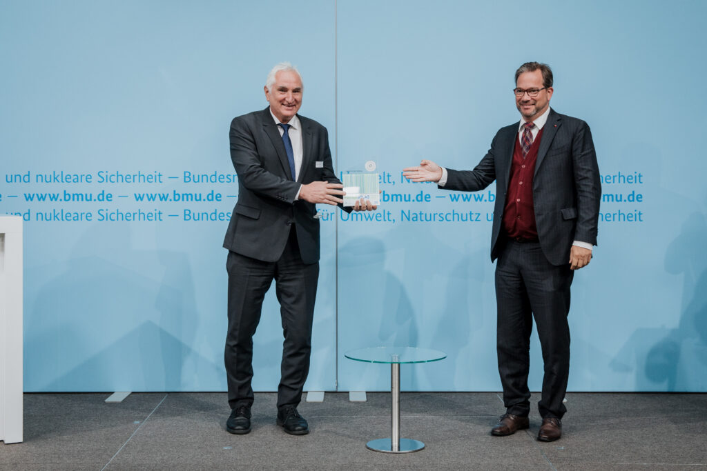 Prof. Dr. Ulrich Bartosch, Präsident der Universität Passau, nimmt den Award für die Auszeichnung als "Aufsteiger des Jahres" von Parlamentarischer Staatssekretär Florian Pronold entgegen. © BMU/Sascha Hilgers