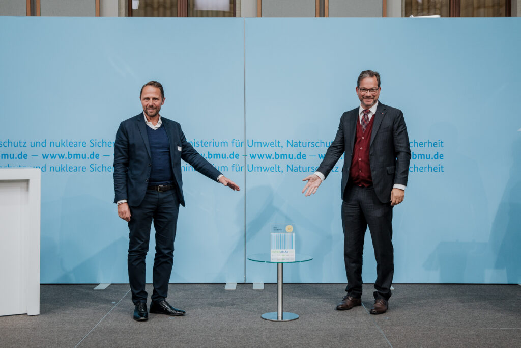 Uwe Richrath, Oberbürgermeister der Stadt Leverkusen, nimmt den Award für die Auszeichnung als "Recyclingpapierfreundlichste Stadt" von Parlamentarischer Staatssekretär Florian Pronold entgegen. © BMU/Sascha Hilgers